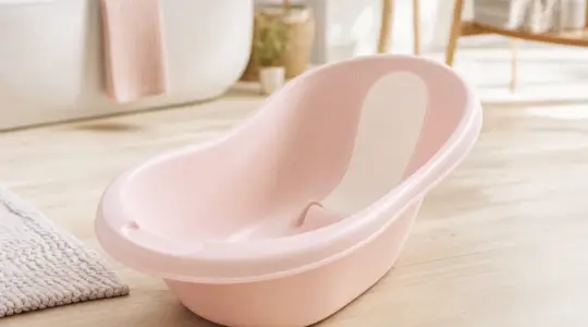 Ergonomische Baby-Badewanne aus Kunststoff in zarter Farbe in einem hellen, freundlichen Badezimmer