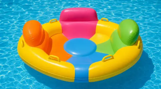 Eine fröhlich bunte aufblasbare Badeinsel treibt auf dem ruhigen Wasser eines sonnigen Pools