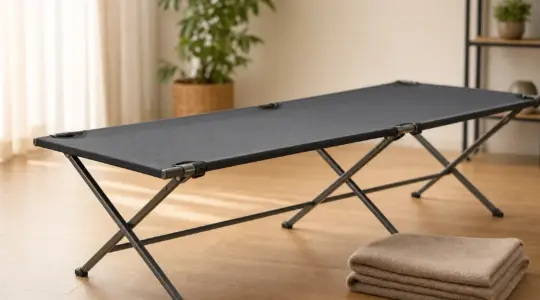 Ein stabiles, aufgebautes Feldbett mit straff gespannter Liegefläche steht einsatzbereit in einem hellen, freundlichen Raum