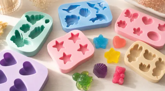 Mehrere bunte Silikon-Gießformen in verschiedenen Motiven mit fertig gegossenen Figuren