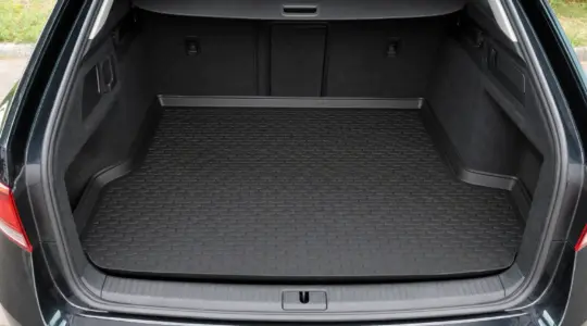 Eine schwarze Kofferraumwanne aus Gummi liegt im offenen Kofferraum eines Autos