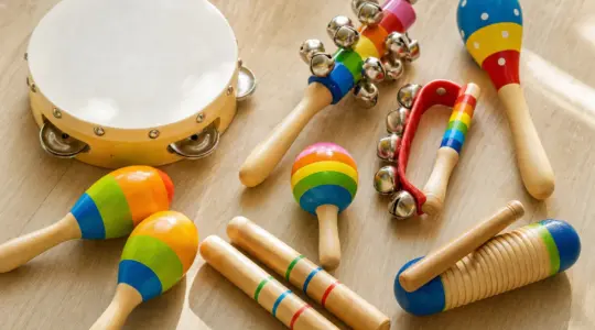 Ein buntes Set Kinder-Musikinstrumente aus Holz mit Tamburin, Rasseln und Klanghölzern