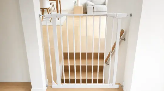 Ein weißes Treppenschutzgitter ist am oberen Ende einer Treppe montiert